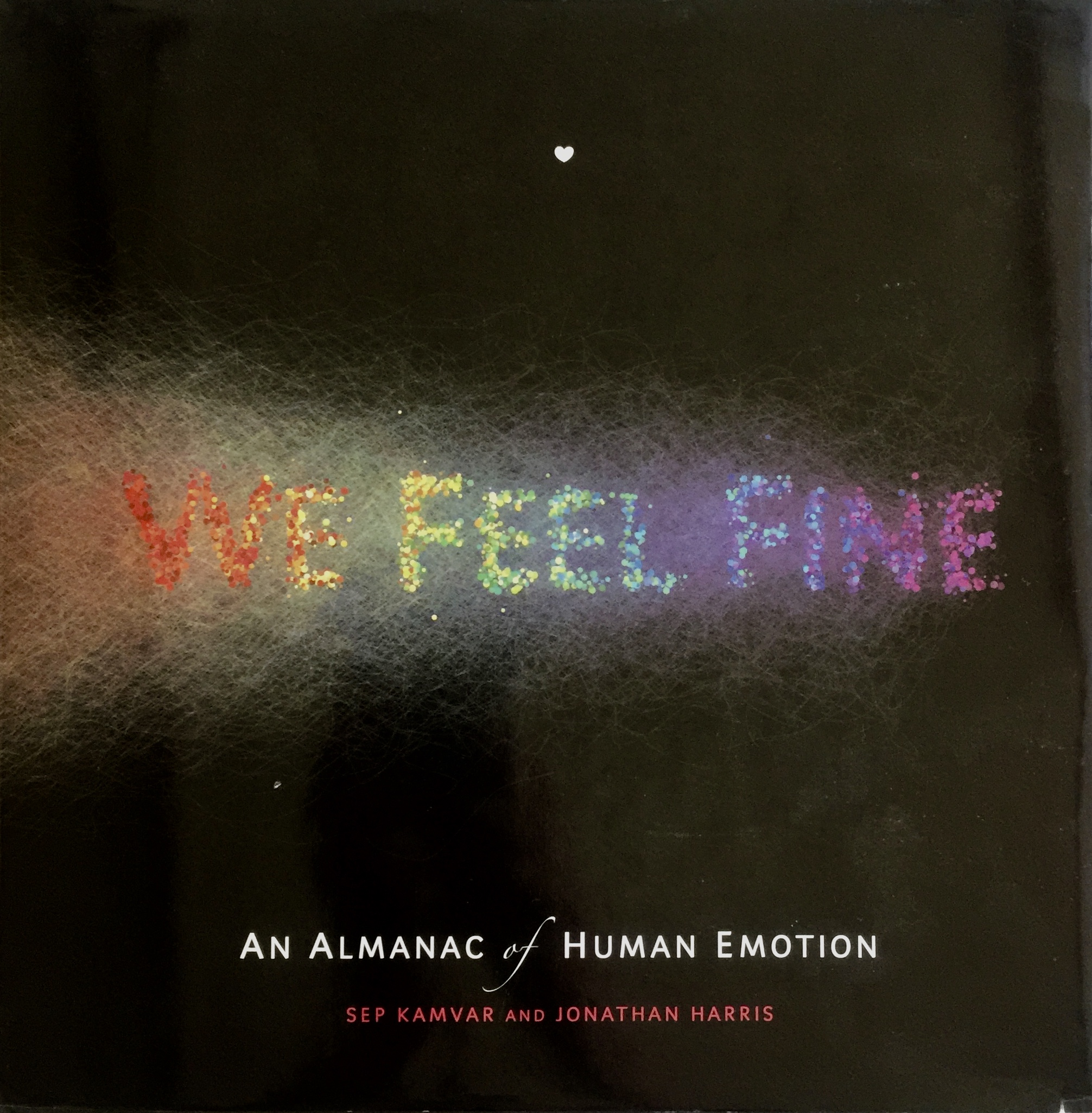 The cover of the book We Feel Fine, with the words formed from the color of a dense data visualization