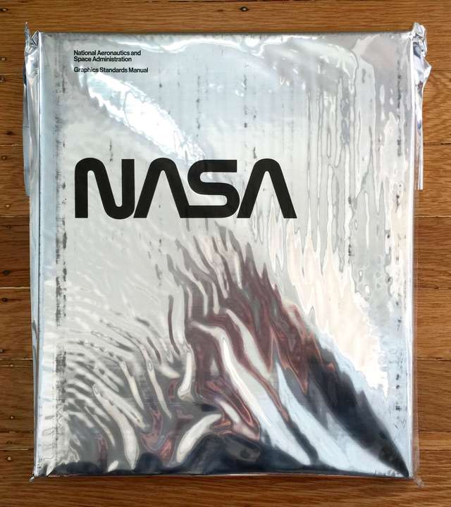 The NASA brand guidelines book, reissued in a Mylar wrapper