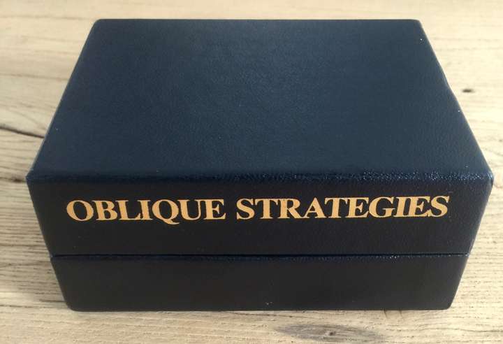 A black box, on it in gold it says Oblique Strategies