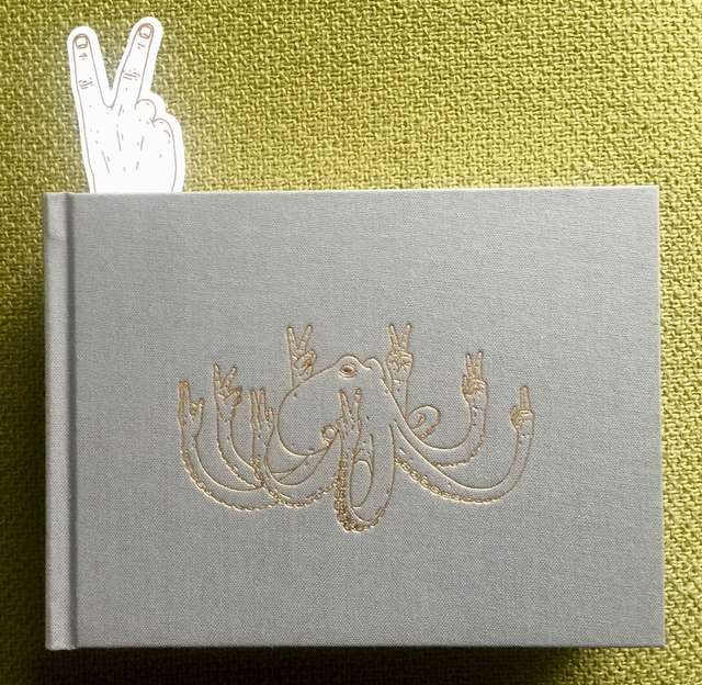 The book Hate Mail, in grey with a golden octopus on the cover making the V sign with all 8 arms