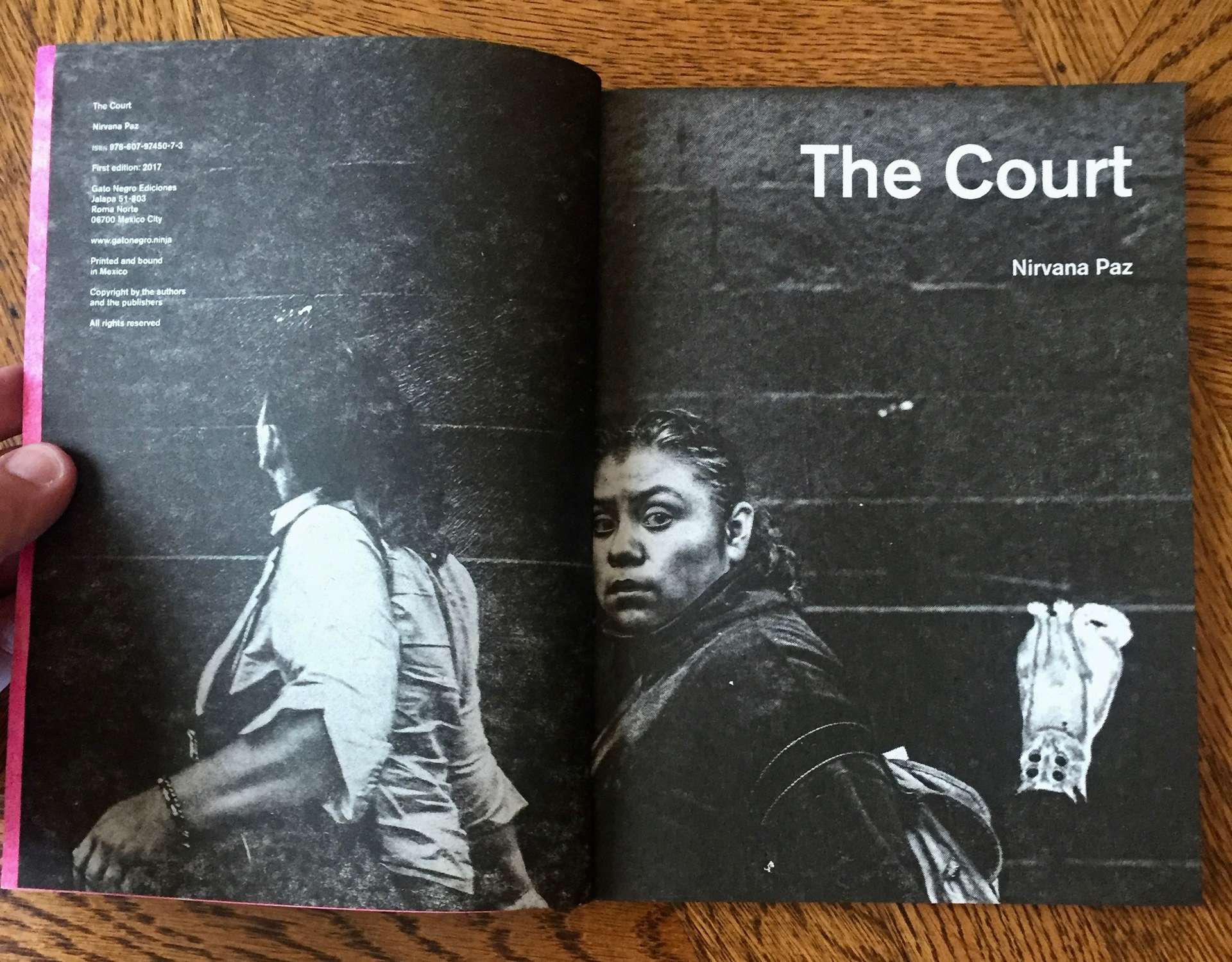 A spread from The Court. It is a dense black page with a monochrome image of 2 women