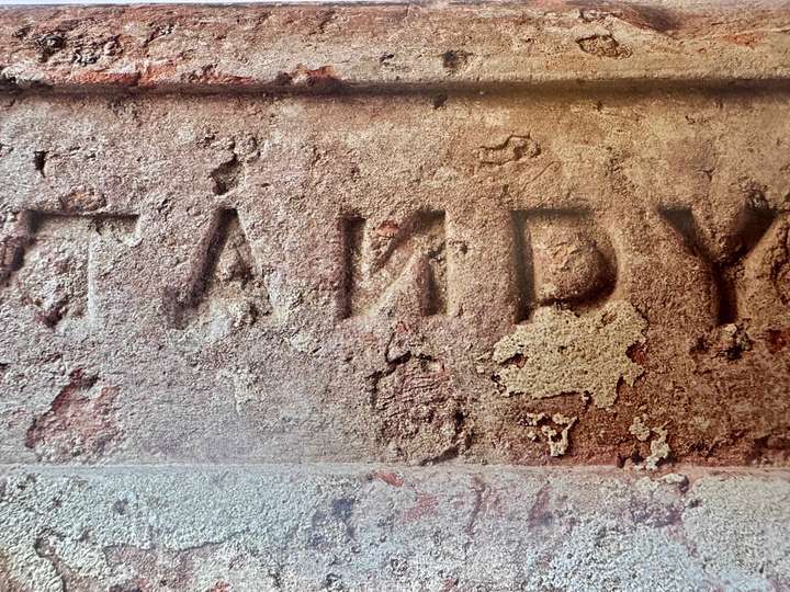 stamped letters on a brick, the N is backwards