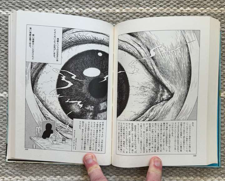 A giant eye, with a small person made as a paper image at the bottom