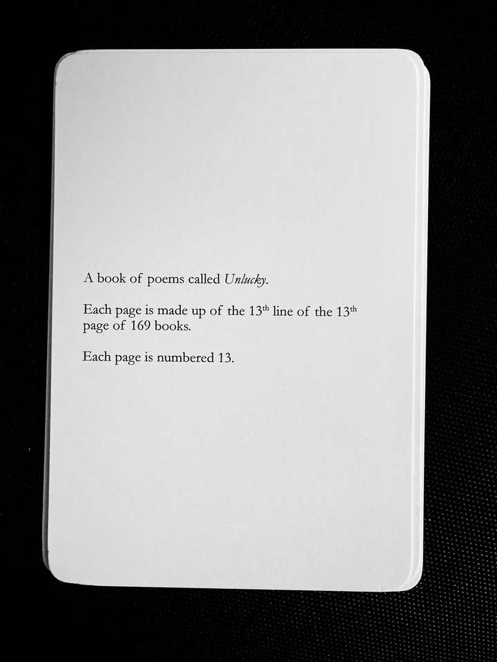 A card saying: A book of poems called Unlucky. Each page is made up of the 13th line of the 13th page of 169 books. Each page is numbered 13.