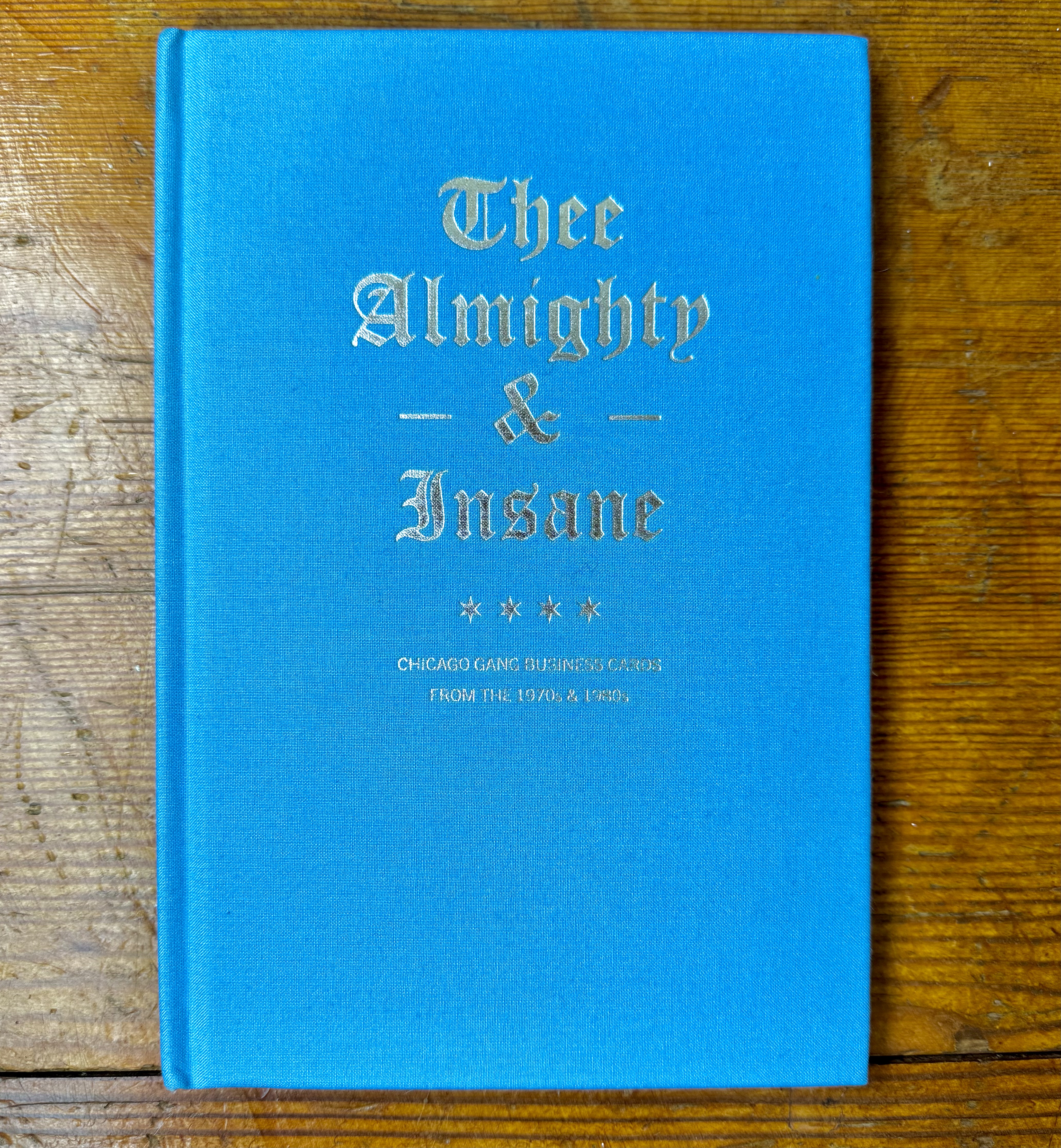 A blue cloth book with gold embossed elaborate title, it says Thee Almighty and Insane